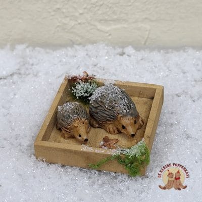 Miniatuur houten bakje met twee egeltjes en winterdecoratie
