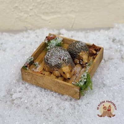 Miniatuur houten bakje met twee egeltjes en winterdecoratie