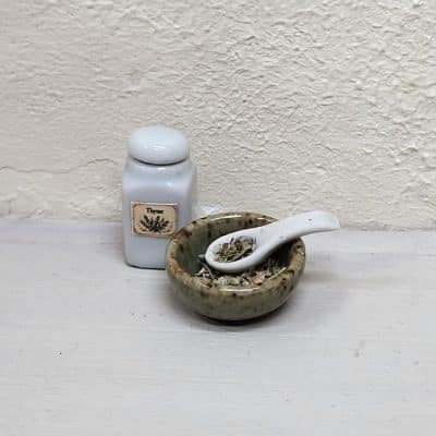 Miniatuur kruidenpotje en een kommetje met lepel en kruiden, schaal 1:12.